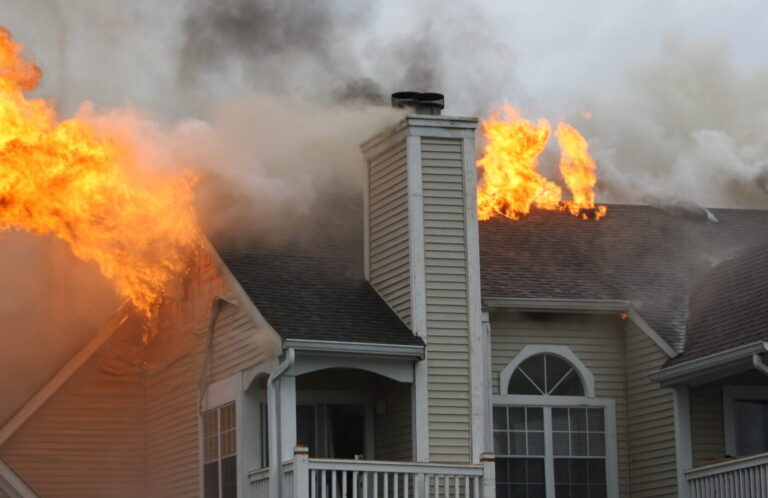 Apartment Building on fire - flames billowing out the roof